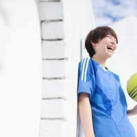 サッカーボールを持ってはじける笑顔のサッカー女子の写真