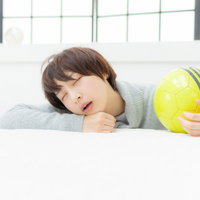 サッカー観戦中に口を開けて爆睡するサッカーガールの写真