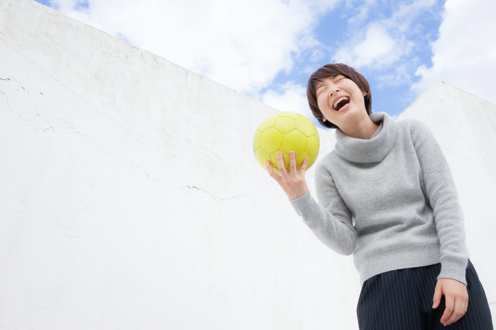 サッカーボールを持って笑う女性［モデル：八木彩香］