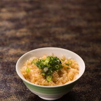 白い茶碗に盛られた卵かけご飯（TKG）召し上がれの写真