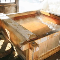 平湯民俗館の源泉かけ流し足湯と天窓から差し込む光の風景の写真