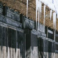 平湯温泉の合掌造りの茅葺屋根にできた巨大なつららの写真
