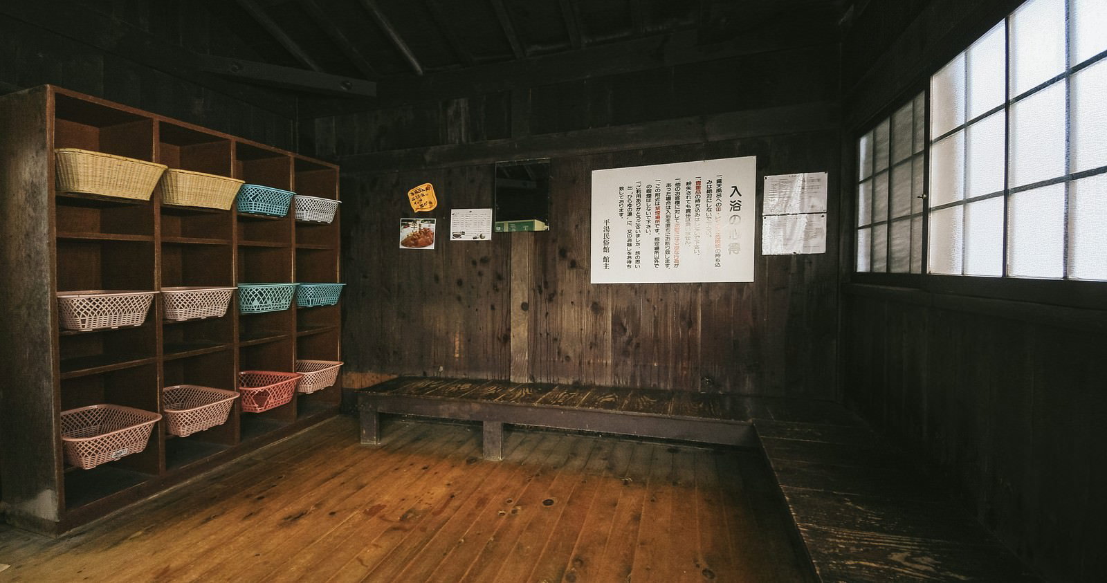 木製棚に竹かごが並ぶ昭和レトロな脱衣所