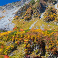 秋の北アルプス涸沢カールで紅葉に染まる涸沢小屋の写真