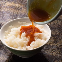 白身と白米をかき混ぜた上に黄身と栄太郎の出汁醤油をかけて完成したTKGの写真