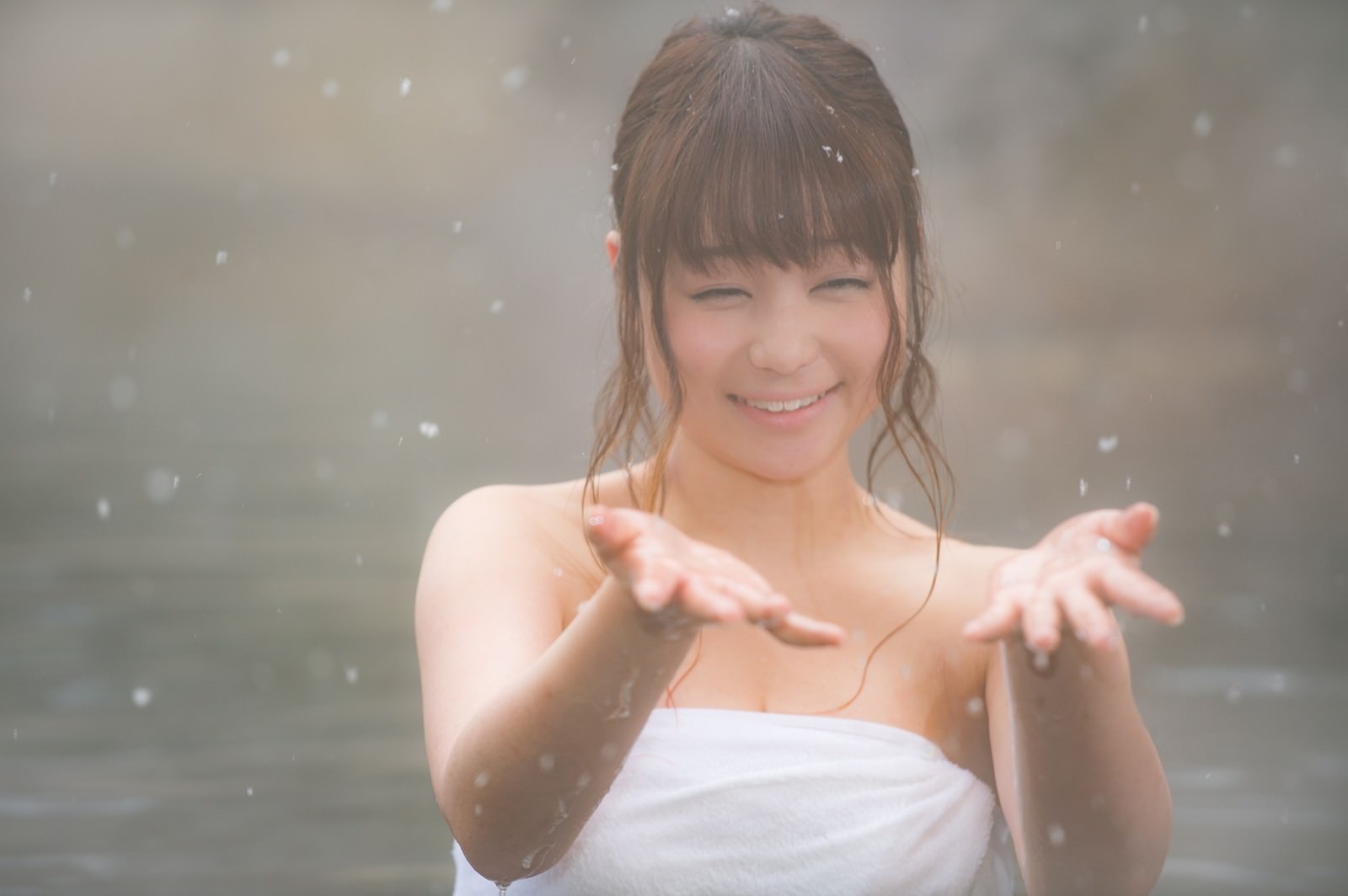 雪が降る露天風呂で入浴している女性の後ろ姿［モデル：茜さや］