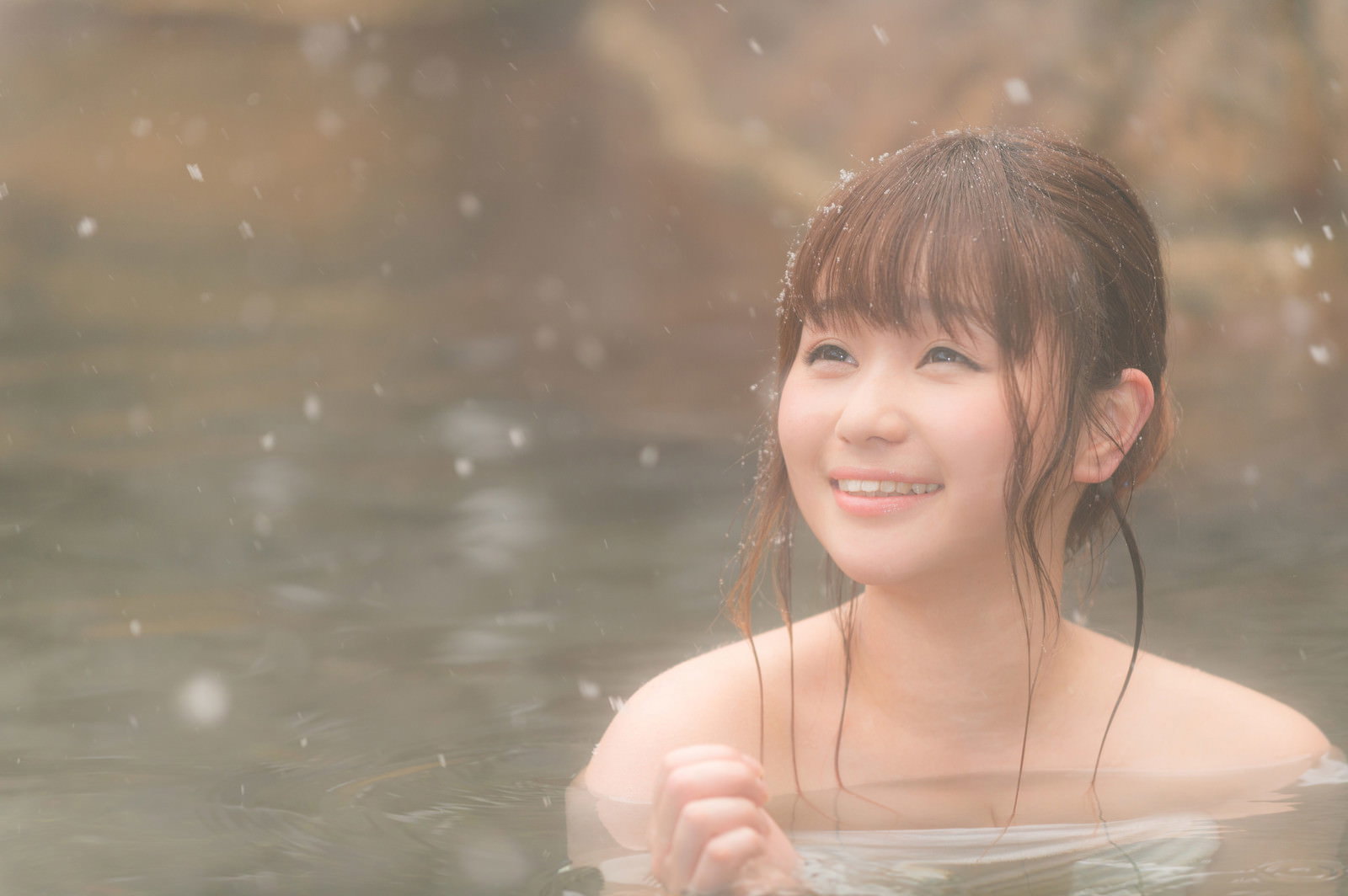降雪の中で露天風呂に入る女性［モデル：茜さや］
