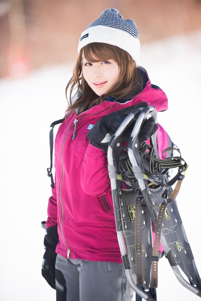 スノーシューを持って雪山に立つ女性［モデル：茜さや］