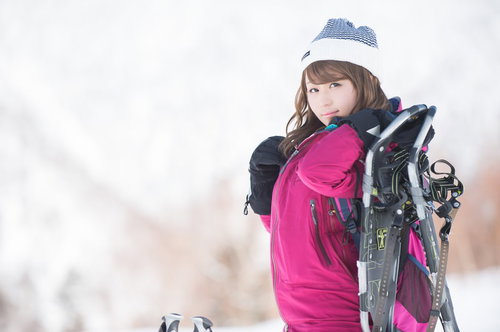 スノーシューを肩に担ぐ冬のアウトドア女性