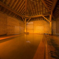 奥飛騨・平湯温泉の檜の露天風呂に流れ込む源泉かけ流しの湯の写真