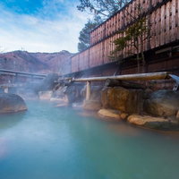 平湯館の大露天風呂で源泉かけ流しを楽しむ紅葉の山並みの写真