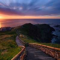 夜明けの襟裳岬、水平線から昇る朝日と木道の写真