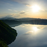 摩周湖の湖面に映る朝焼けとサンライズ（北海道川上郡弟子屈町）の写真