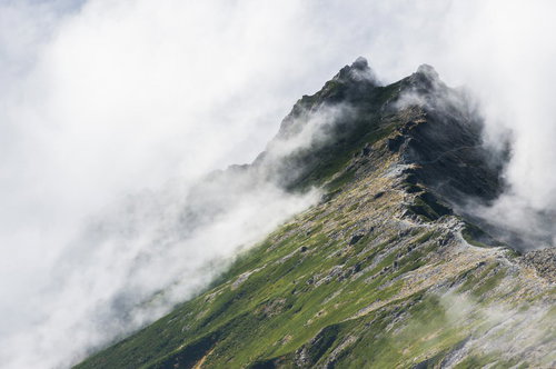 槍ヶ岳と雲海に包まれた北アルプスの山々を望む登山道からの景色