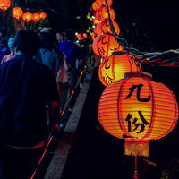 夜の九份で赤く照らされた提灯と人混みの街並みの写真