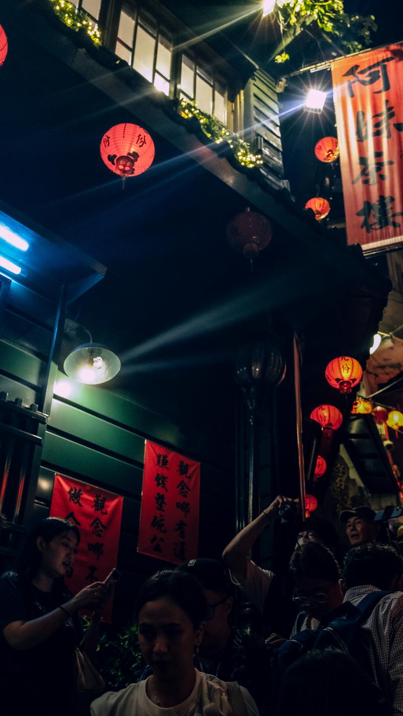 九份の街を照らす赤提灯と街灯、夜間に人々が集まる様子