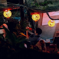 黄色い提灯の灯りの下で歩く九份の夜の路地の写真