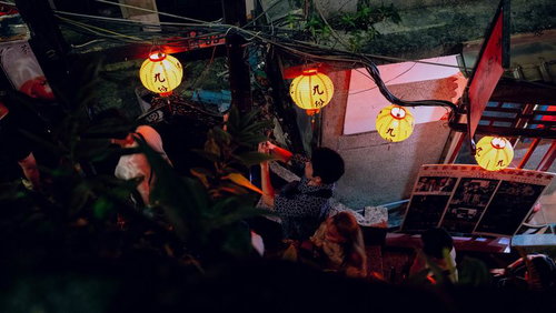 黄色い提灯の灯りの下で歩く九份の夜の路地