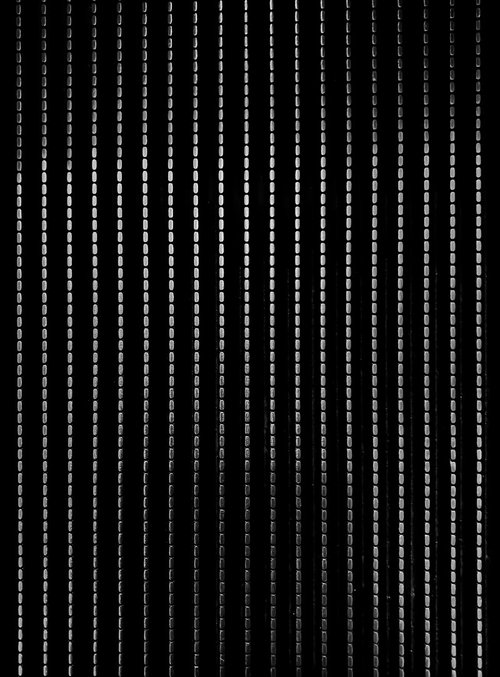 黒い背景に縦に並ぶステンレス鋼鉄の点線テクスチャー