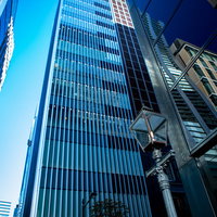 青空をバックに高層ビルに囲まれた街灯の景観の写真