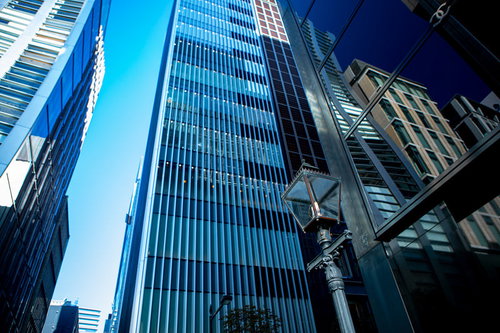 青空をバックに高層ビルに囲まれた街灯の景観