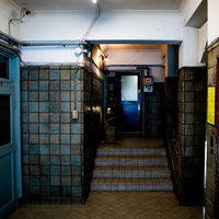 昭和の建築様式が残るレトロなエレベータ前の踊り場と階段の写真