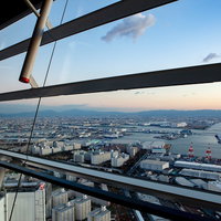 コスモタワーのガラス越しに見た大阪湾の街並み（咲洲庁舎展望台）の写真