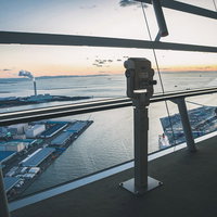 大阪府咲洲庁舎展望台内の双眼鏡と夕暮れ時の湾景の写真