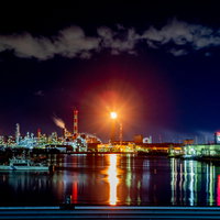 水面に映る川崎工場夜景とフレアスタック、煙突からの炎の写真