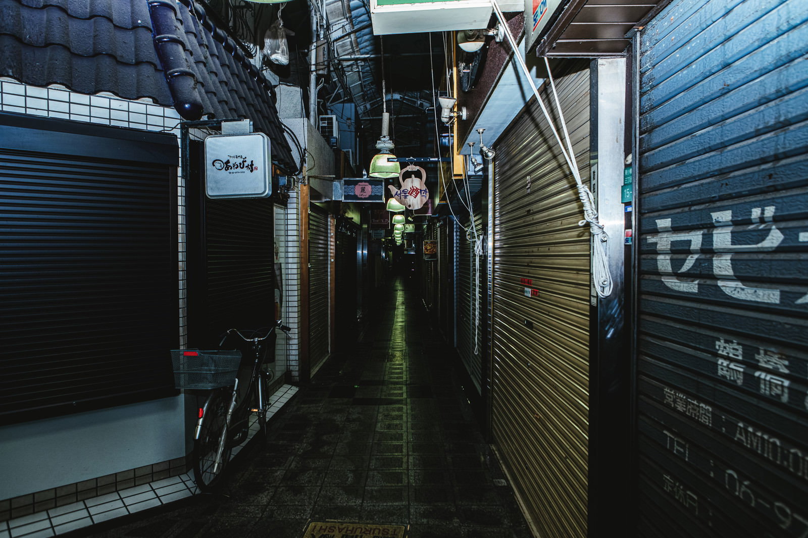 深夜の商店街でシャッターが降りた狭い路地の様子