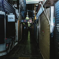 深夜に営業を終えてシャッターが降りた商店街の路地の写真