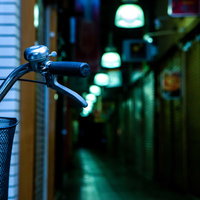 路地裏に停められた自転車のハンドル部分の夜間風景の写真