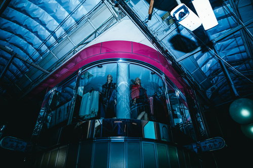 深夜の商店街アーケード内に設置された監視カメラとマネキン