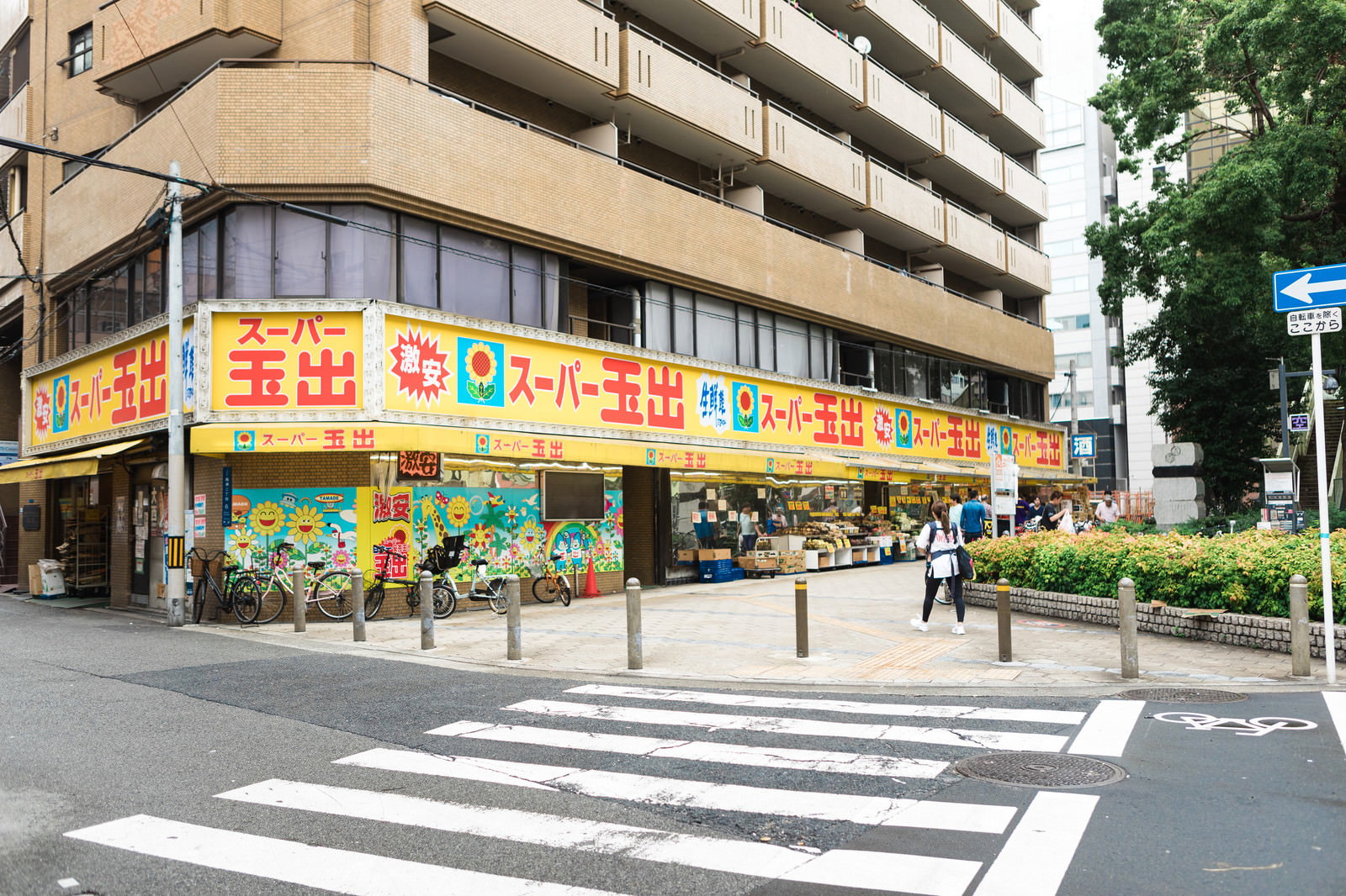 カラフルな看板の激安スーパーと住宅街の街並み