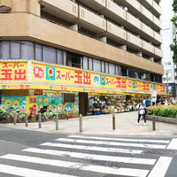 大阪の住宅街に建つカラフルな激安スーパーと街並みの写真