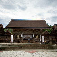 出雲大社の八足門と石段 参拝客が行き来する重厚な木造建築の写真