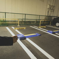 夜の駐車場で車を解錠する男性の写真