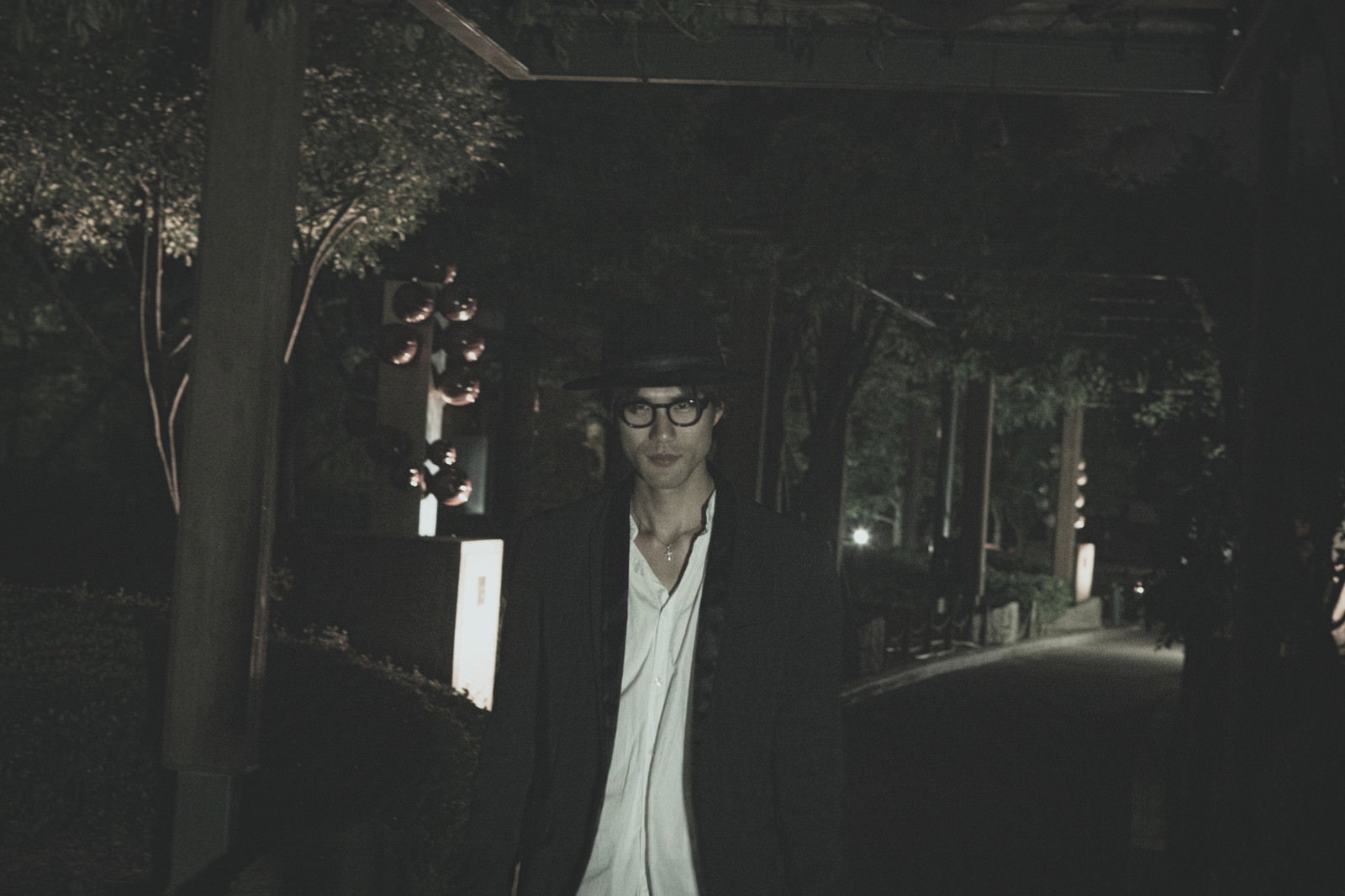 夜間の暗い場所で不気味に人に近づく男性の姿［モデル：村田裕章］