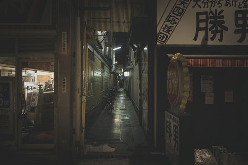 薄暗い路地裏の道、閉店したシャッター街の夜間風景