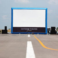 滑走路上に設置された野外映画の大型スクリーンの写真