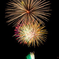 ドドンと打ち上がるオレンジ色の大輪花火が夜空で炸裂する打上花火の瞬間の写真