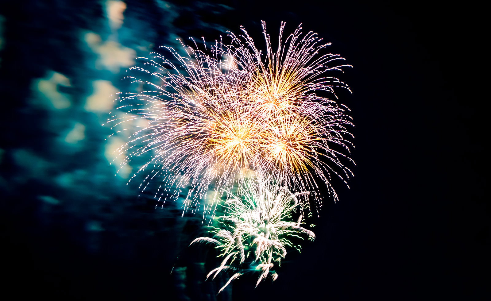 夜空に色とりどりの光を放ちながら炸裂する打ち上げ花火