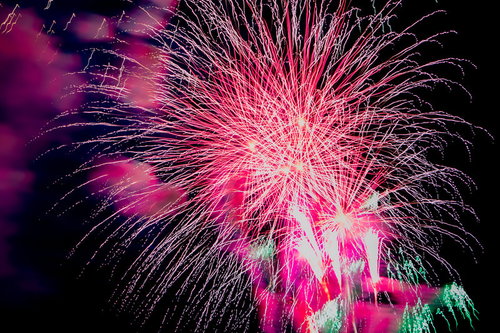 夜空いっぱいに炸裂するピンク紫の打ち上げ花火