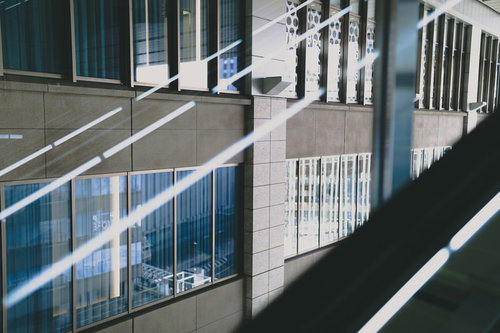 建物の窓ガラスに反射する蛍光灯の明かりと階段