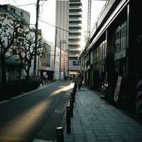夕方の路地に並ぶ店舗と歩道の風景の写真