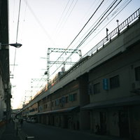 高架橋下に建ち並ぶ商店街の街並みと都市風景の写真