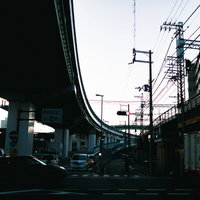 曇り空の下の高速道路出口と高架橋が交差する都市インフラの写真