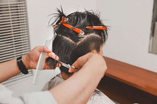 オレンジのカラーバンドを使用したメンズヘアカットシーン