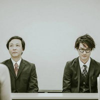 企業不祥事の謝罪会見で記者の質問に応じる男性役員たちの写真
