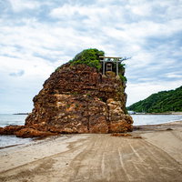 稲佐の浜の砂浜沖に立つパワースポット弁天島と鳥居の写真